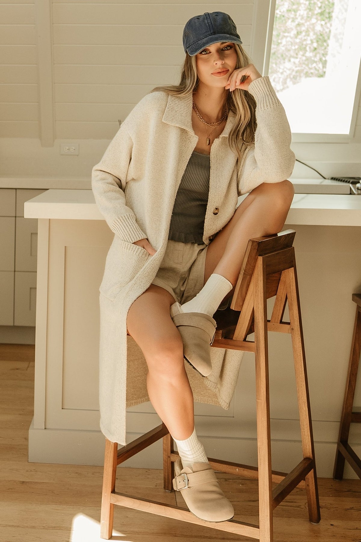 Model styling the oatmeal longline cardigan with two-button waist fastened, demonstrating gentle drape and subtle shaping at the waist.