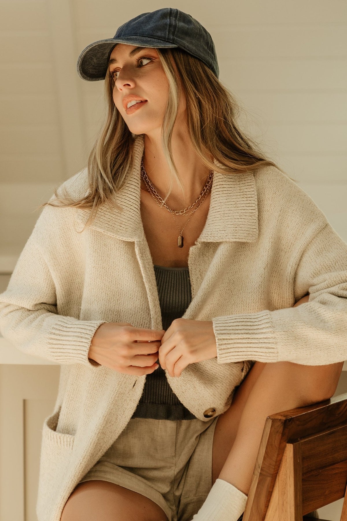 Detail view of patch pocket and ribbed cuff on oatmeal cardigan, illustrating functional pockets and refined rib finishing.