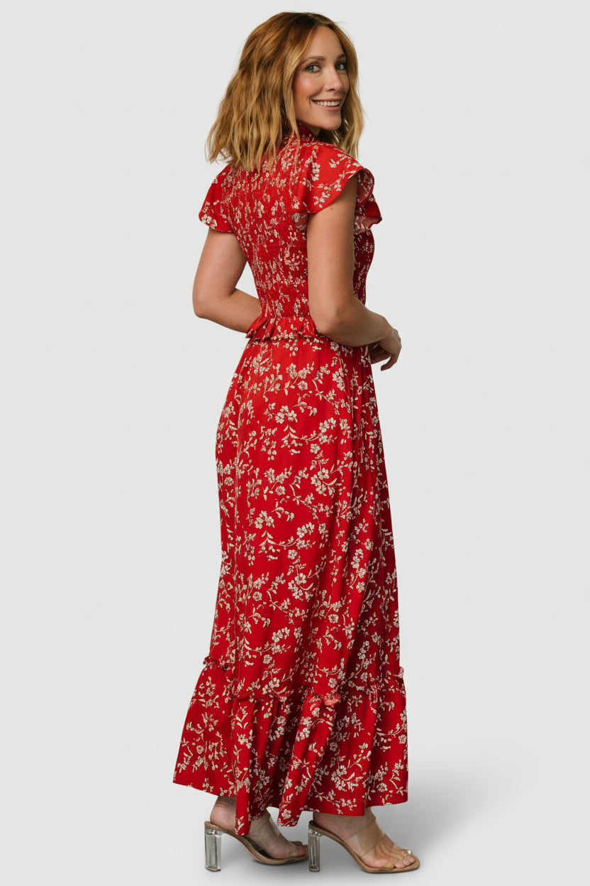 Detail shot of short flutter sleeve and shoulder seam on red floral chiffon dress, showing lightweight drape.