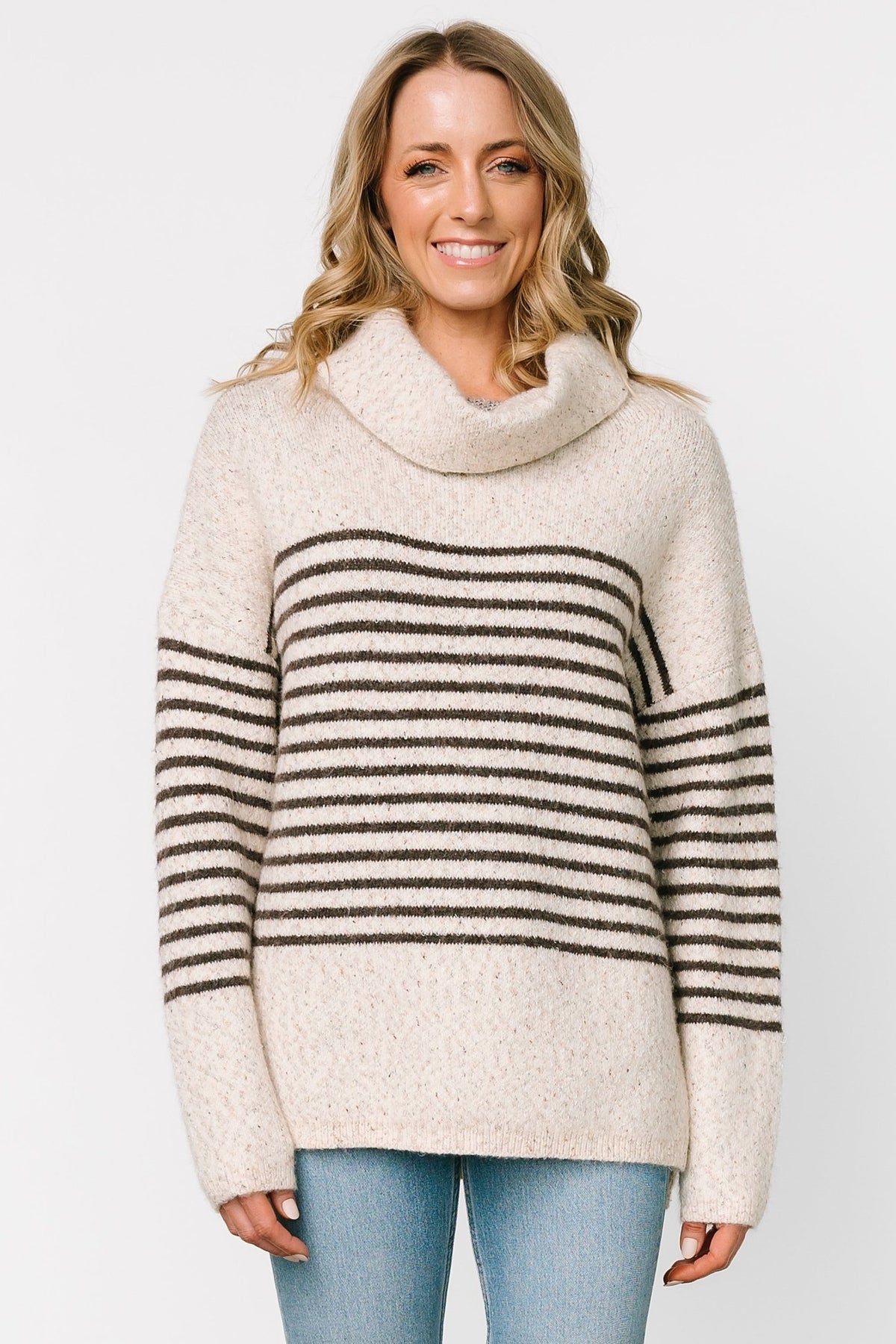Front model view of Pennington turtleneck sweater in speckled cream with dark multi-stripes, ribbed cuffs and split side hem.