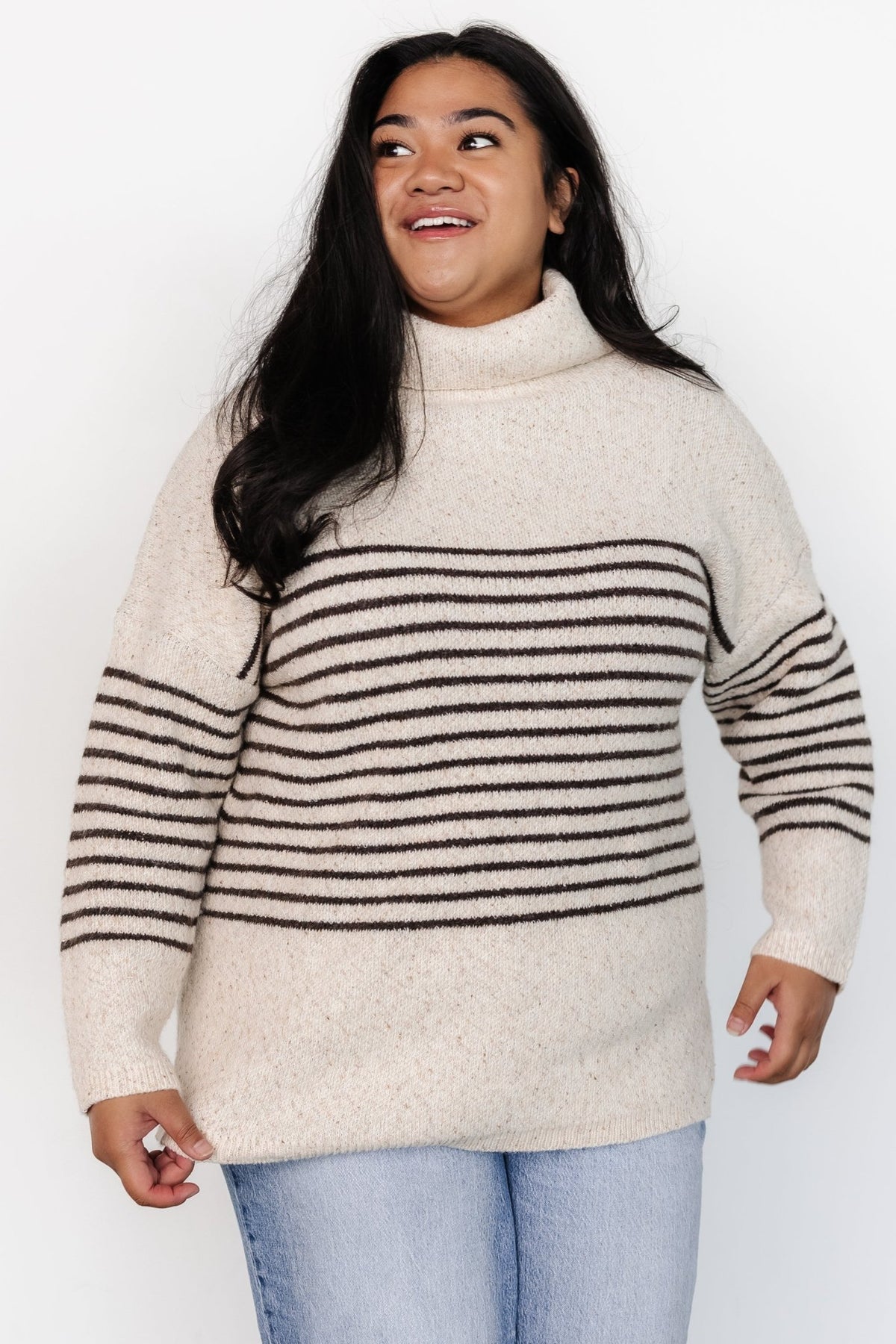 Front model view of Pennington turtleneck sweater in speckled cream with dark multi-stripes, ribbed cuffs and split side hem.