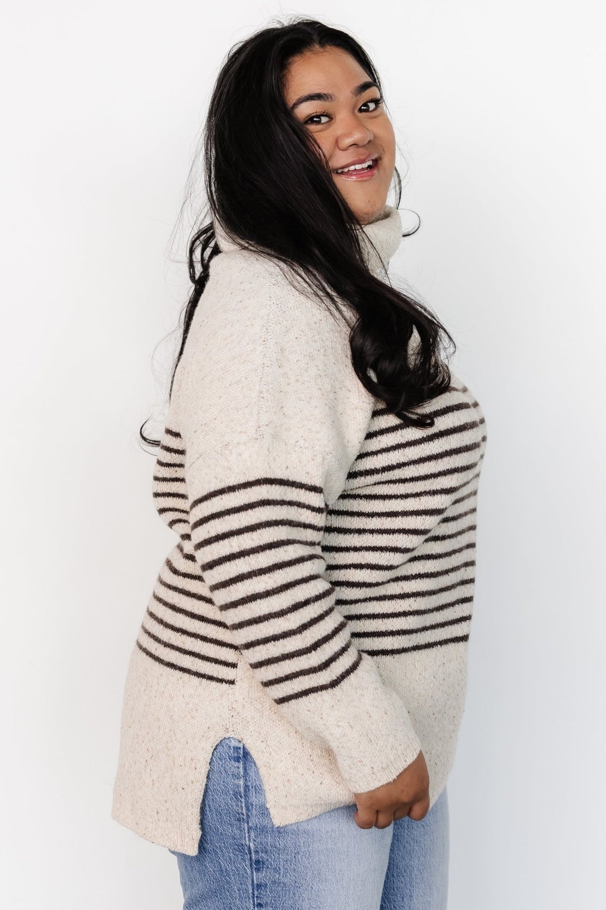 Front model view of Pennington turtleneck sweater in speckled cream with dark multi-stripes, ribbed cuffs and split side hem.