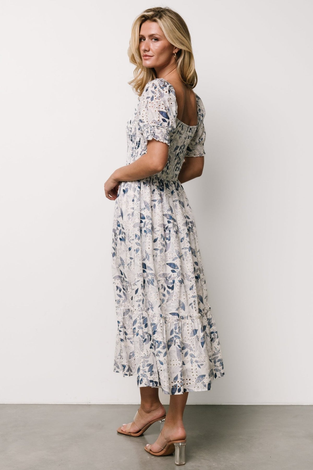 Back view of midi dress showing smocked back bodice, elastic at shoulder and full lined skirt in floral eyelet fabric.