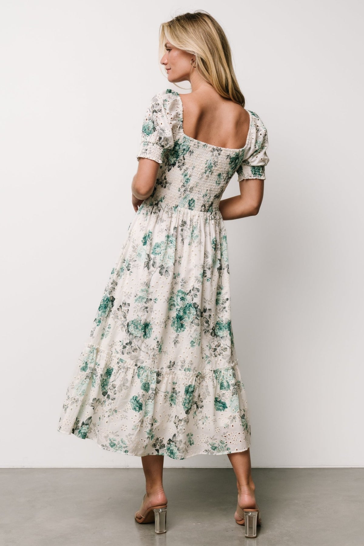 Detail shot of the Piper Eyelet Midi Dress showing smocked front, sweetheart neckline and ruffle sleeve edge.