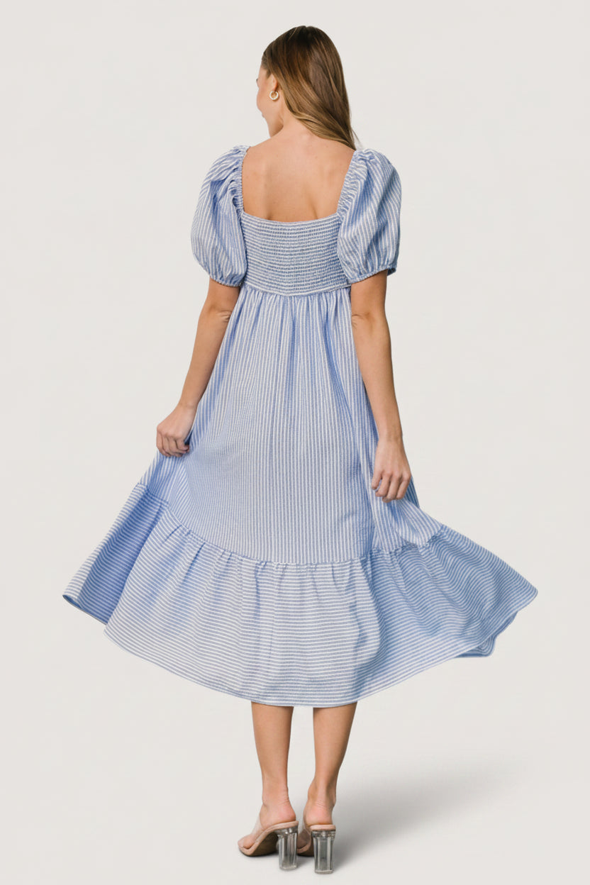 Styled look of the Poppy Midi Dress in blue stripes paired with neutral accessories, illustrating occasion styling for day or night.