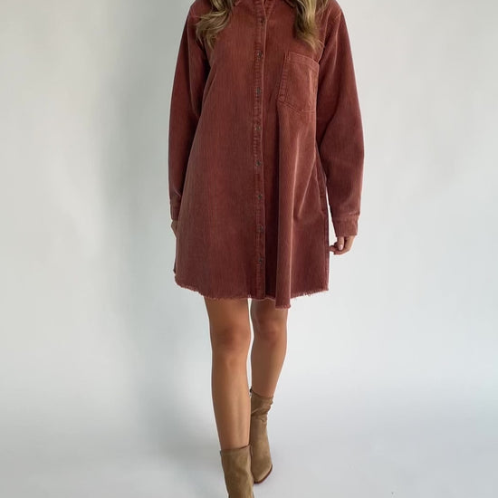 Dusty clay corduroy button-front shirt jacket with a collared neckline, oversized fit, chest pocket, long sleeves, and a rounded high-low hem.