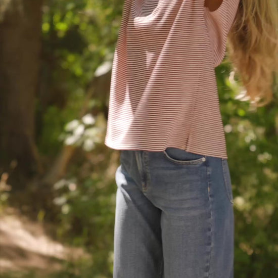 Bria High Rise Wide Leg Jeans in Medium Wash with relaxed wide legs, front and back pockets, button closure, and raw hem.