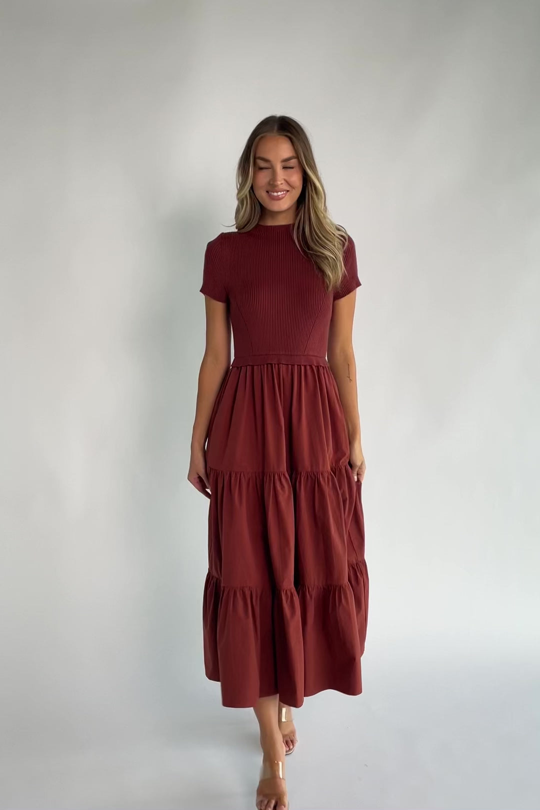Midi dress with a ribbed knit bodice, round neckline, short sleeves, elastic waist, tiered woven skirt, and side pockets.