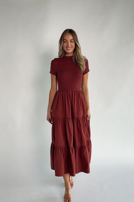 Midi dress with a ribbed knit bodice, round neckline, short sleeves, elastic waist, tiered woven skirt, and side pockets.
