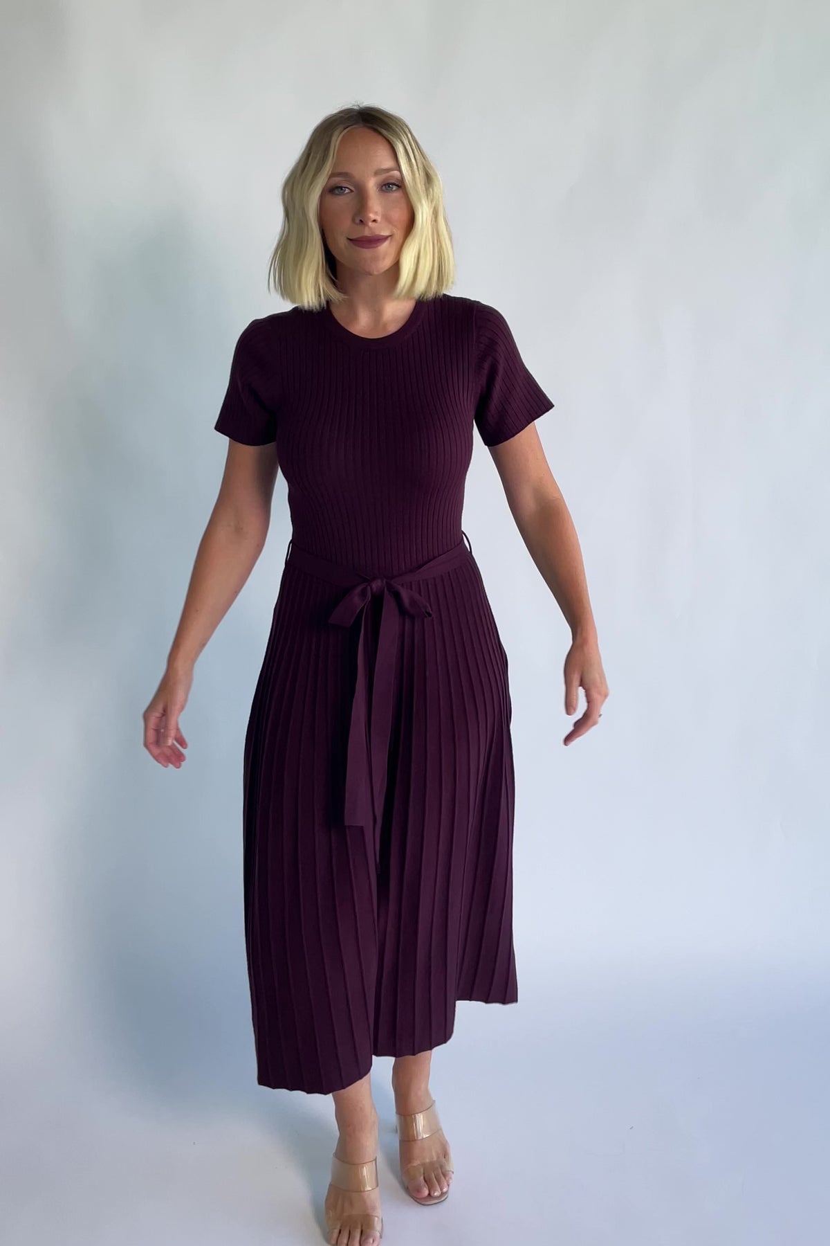 Jessamine Midi Dress in Dark Plum with a ribbed sweater knit, crew neckline, waist belt, and pleated midi skirt.