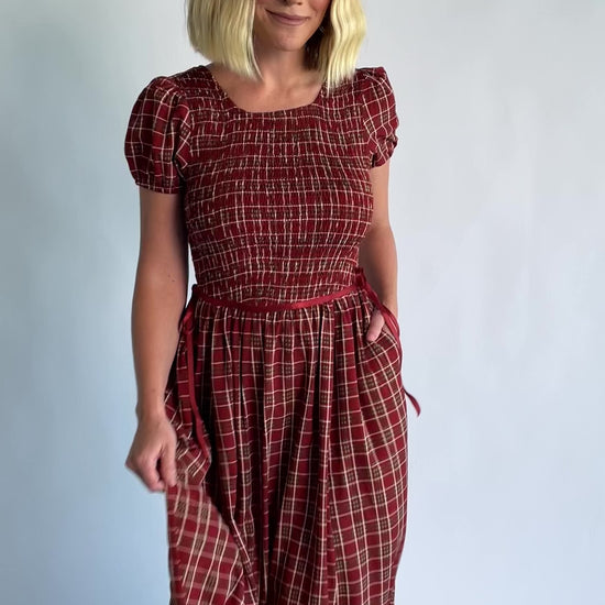 Lorelei Smocked Dress in Red Print with round neckline, smocked bodice, and elastic sleeves.