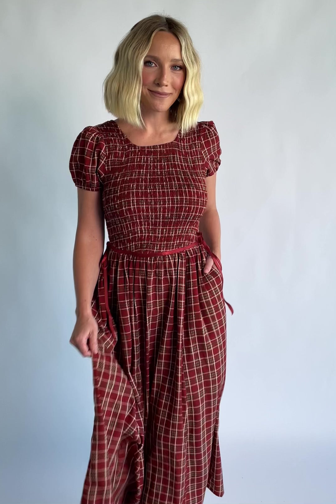 Lorelei Smocked Dress in Red Print with round neckline, smocked bodice, and elastic sleeves.