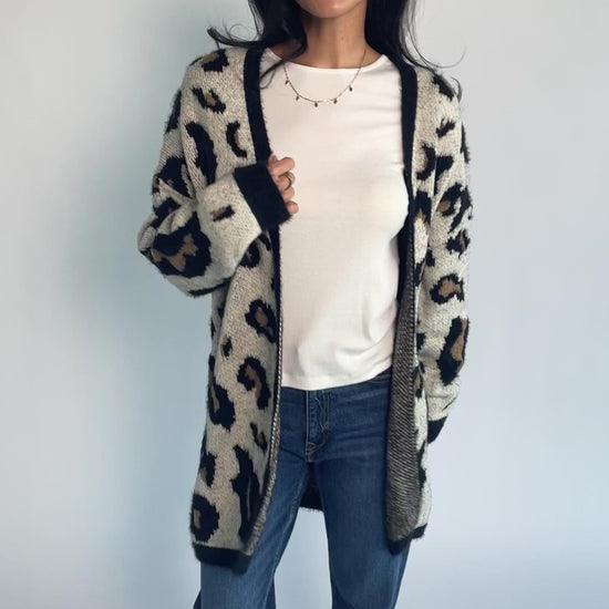 Model wearing the Jeter Open Cardigan in Leopard Print featuring a neutral knit with black and camel leopard print.