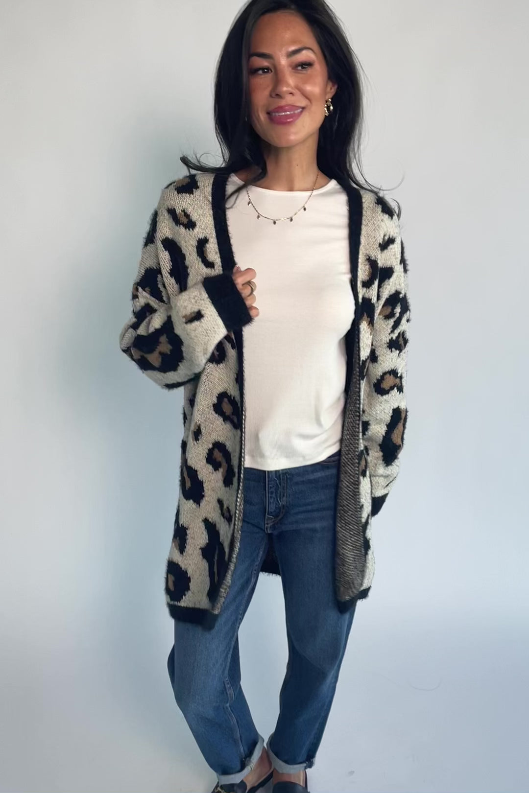 Model wearing the Jeter Open Cardigan in Leopard Print featuring a neutral knit with black and camel leopard print.