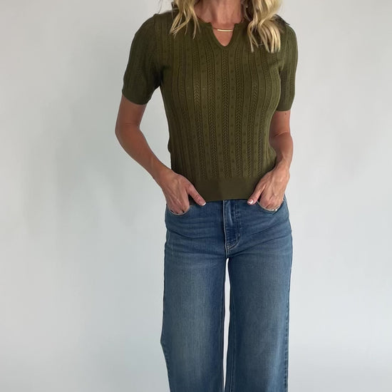Pointelle knit top with a crew neckline, notch detail, short sleeves, and ribbed cuffs and hem.