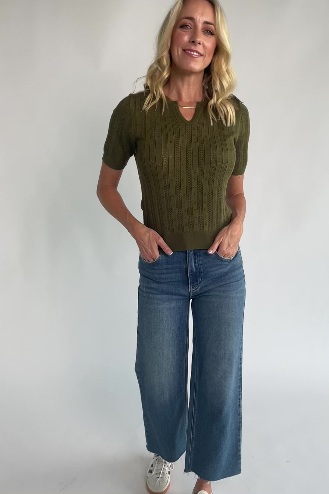 Pointelle knit top with a crew neckline, notch detail, short sleeves, and ribbed cuffs and hem.