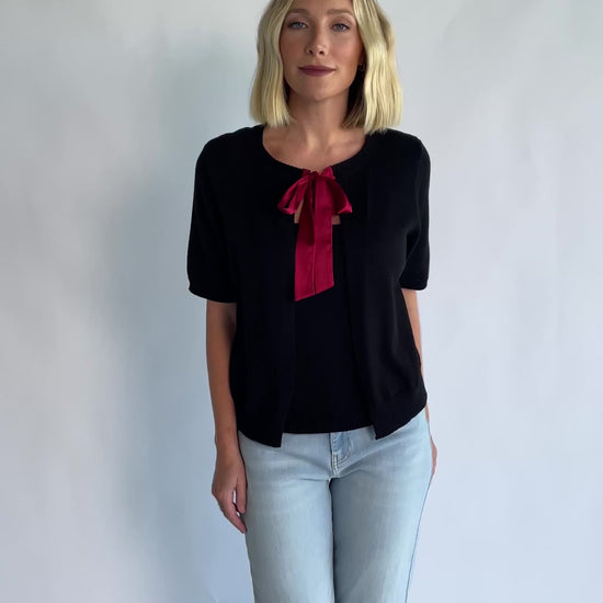 Shaye Sweater Top in Black with a built-in tank, satin bow tie closure, and soft knit construction.