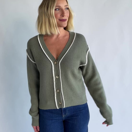 Clarke Button Up Cardigan in Dusty Sage with tortoise-colored buttons, white piping details, and a button-front design.