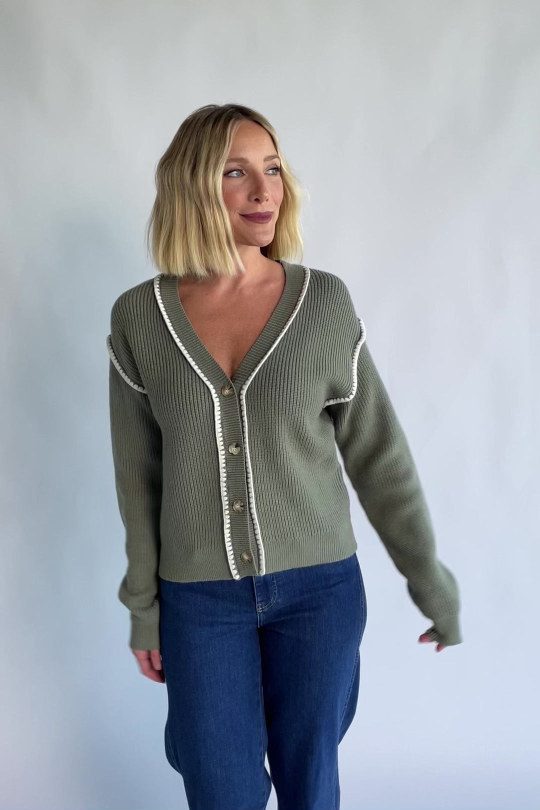 Clarke Button Up Cardigan in Dusty Sage with tortoise-colored buttons, white piping details, and a button-front design.