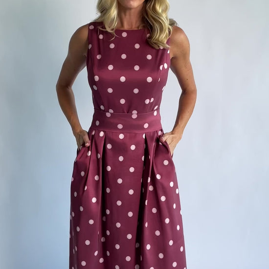 Chiara Midi Dress in Wine + Pink Dot with a boat neckline, pleated full skirt, and a fitted sleeveless bodice.