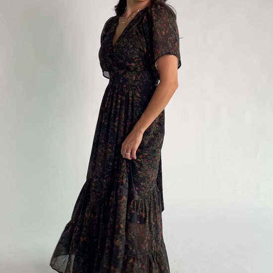Katherine Maxi Dress in Black Multi Print with surplice V-neck, flutter sleeves, adjustable waist ties, and tiered skirt.