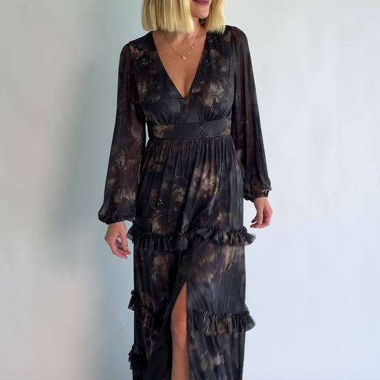 Astraea Maxi Dress in Midnight Floral with a deep V-neckline, sheer sleeves, and a tiered maxi skirt with leg slit.