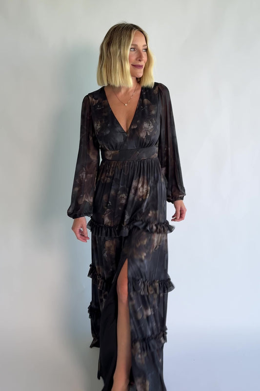 Astraea Maxi Dress in Midnight Floral with a deep V-neckline, sheer sleeves, and a tiered maxi skirt with leg slit.