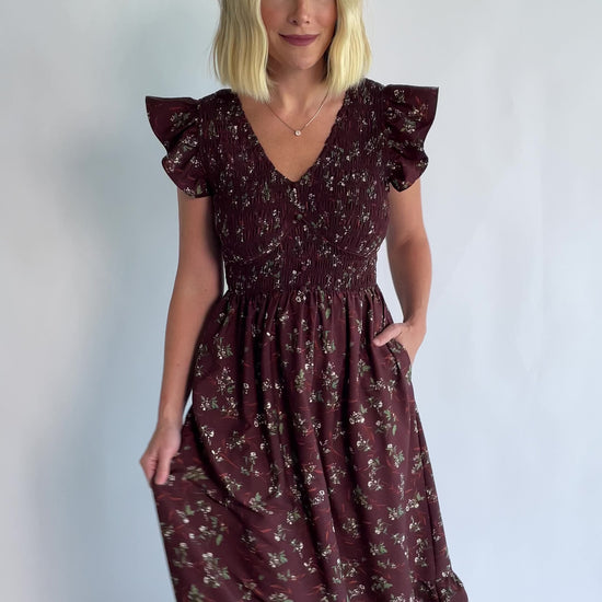 Tilly Smocked Dress in Dark Clove Floral with a V-neckline, flutter sleeves, and a smocked empire bodice.