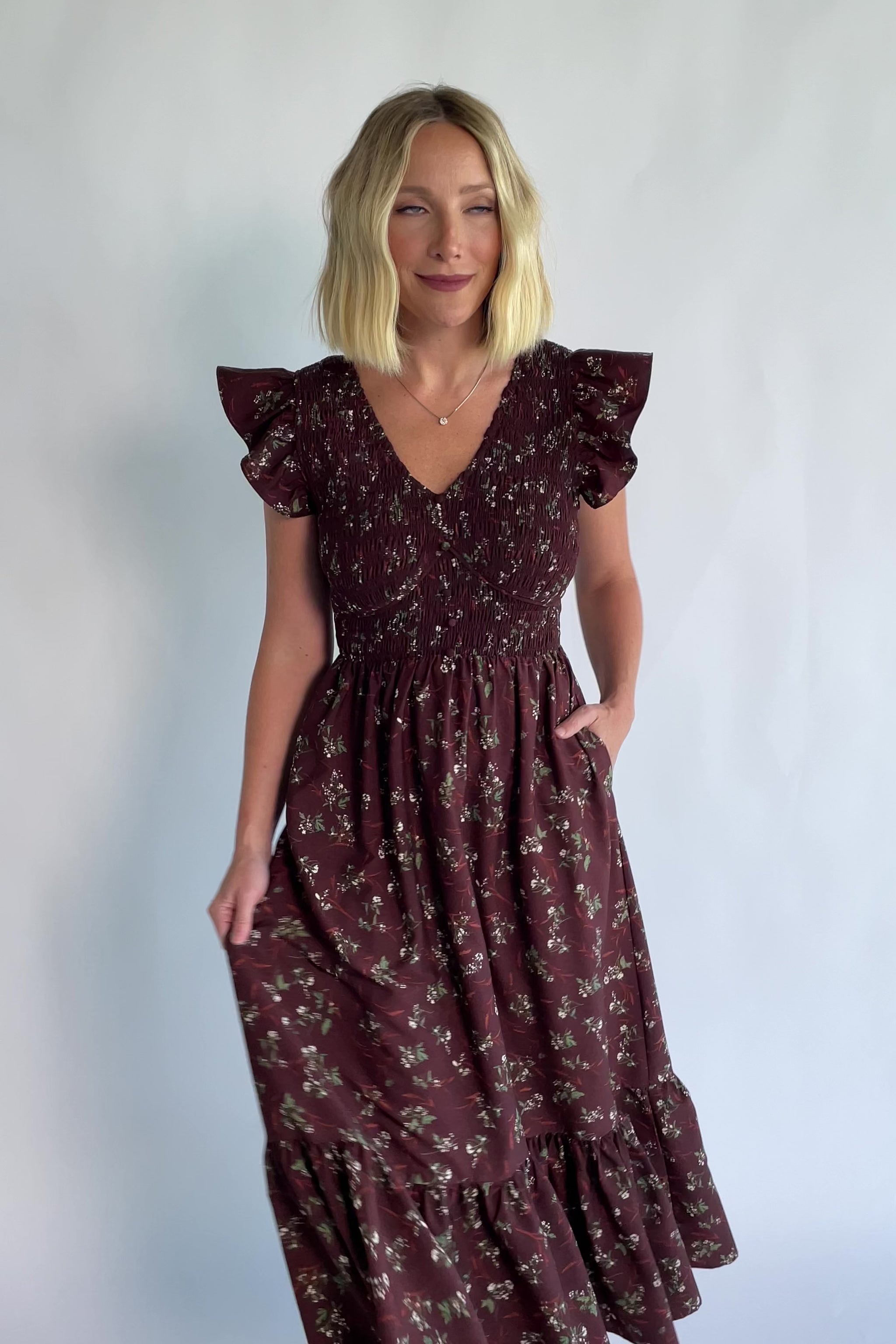 Tilly Smocked Dress in Dark Clove Floral with a V-neckline, flutter sleeves, and a smocked empire bodice.