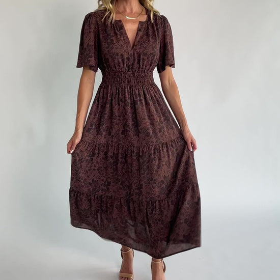 Espresso floral maxi dress with a split V-neckline, flutter sleeves, smocked waist, and flowing tiered skirt.