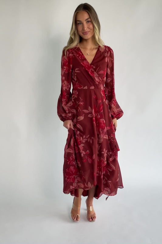 Rust multi floral chiffon maxi dress with a faux wrap neckline, long balloon sleeves, adjustable waist tie, and a high-low skirt.