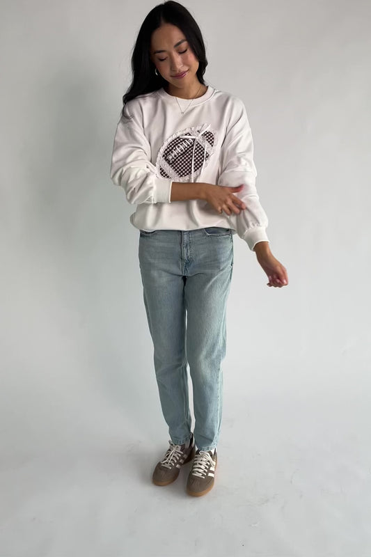 Stephen Gingham Crewneck in Ivory with brown gingham lace appliqué, ribbon bow detail, long sleeves, and ribbed trim.