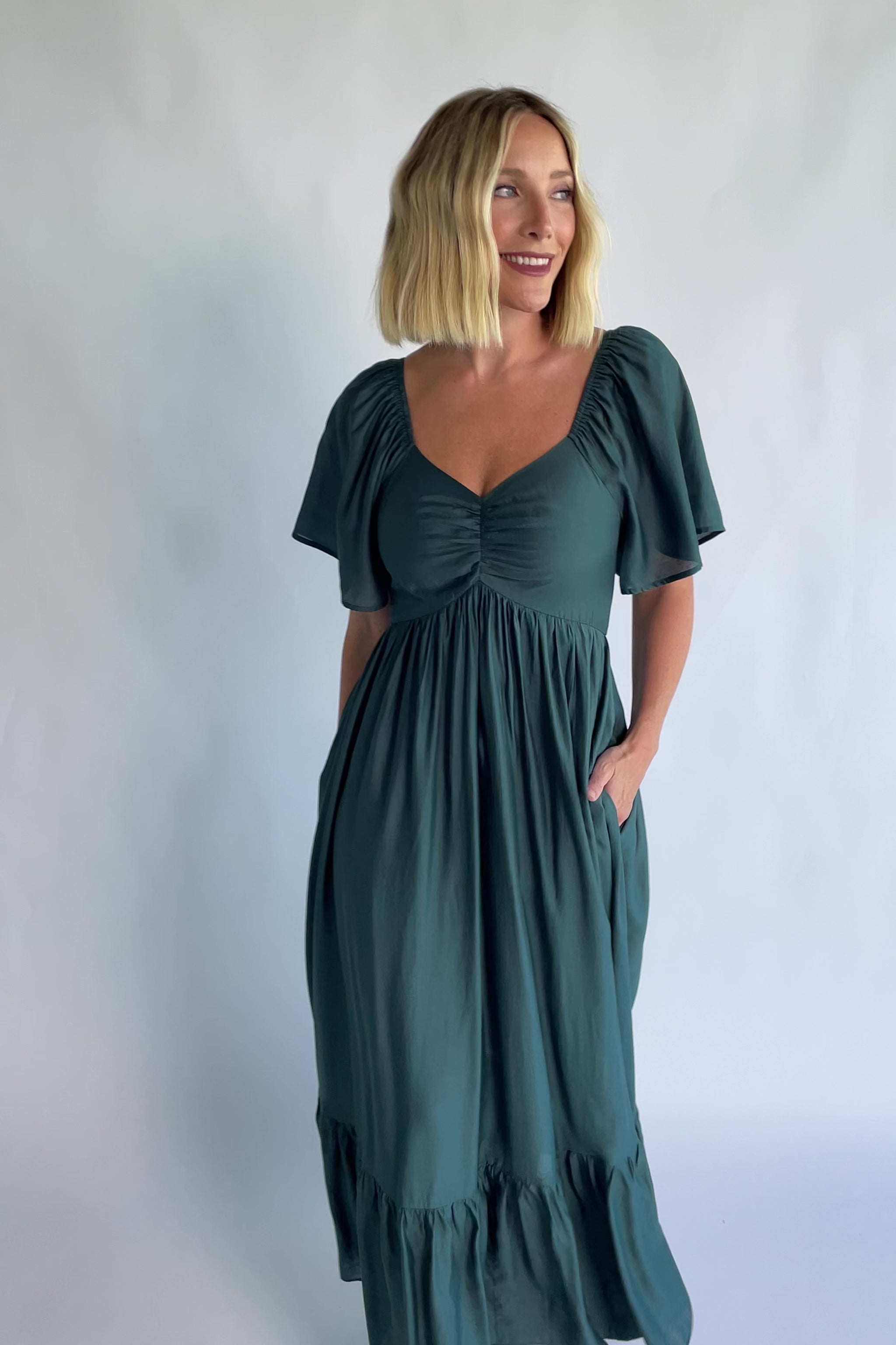 Anisa Midi Dress in Emerald with a V-neckline, cinched bust, and elastic shoulders.