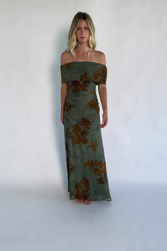 Model wearing an off-the-shoulder maxi dress with a green mesh overlay and copper velvet floral detailing.