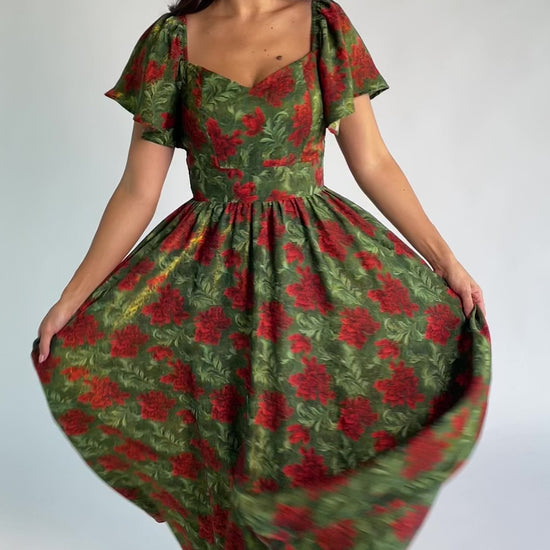 Astor Maxi Dress in Green + Red with floral print, sweetheart neckline, flutter sleeves, smocked back, and flowing skirt.