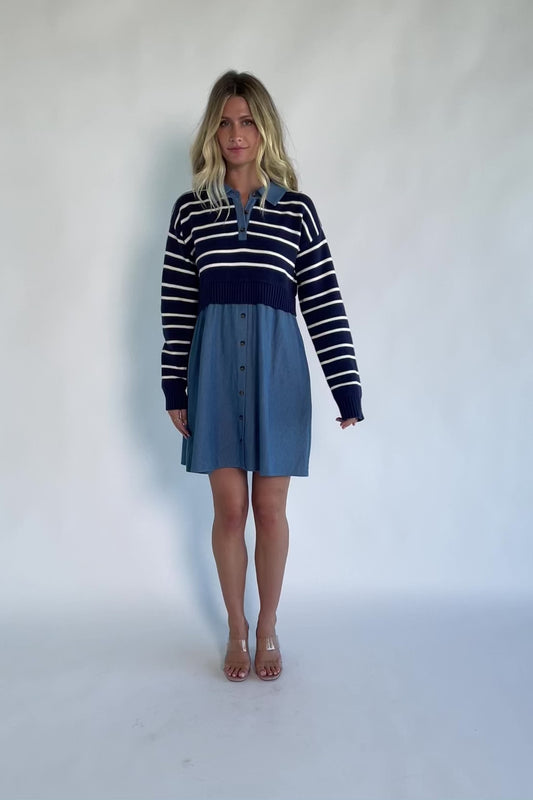 Model wearing a navy and ivory striped sweater dress with a collared neckline, functional button-front detail, long sleeves, and an elastic waist.