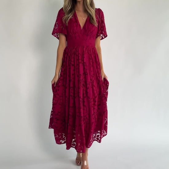 Floral lace midi dress with a deep V-neckline, short flutter sleeves, smocked back bodice, defined waistband, and tiered skirt.