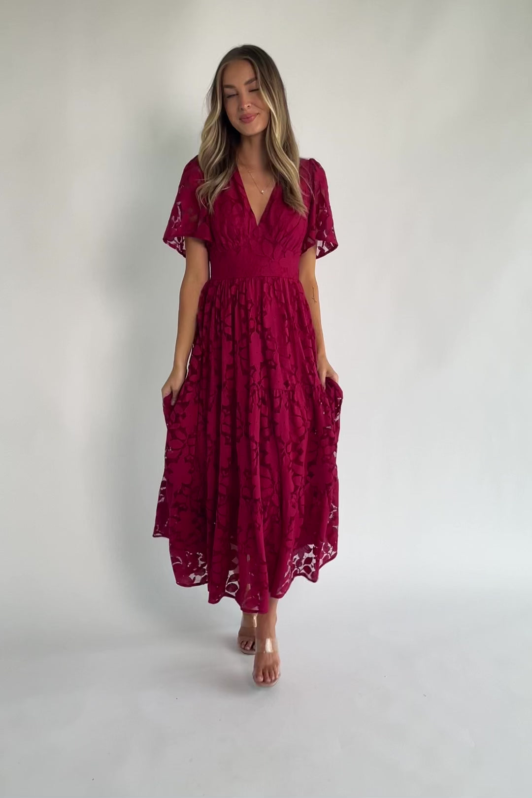 Floral lace midi dress with a deep V-neckline, short flutter sleeves, smocked back bodice, defined waistband, and tiered skirt.