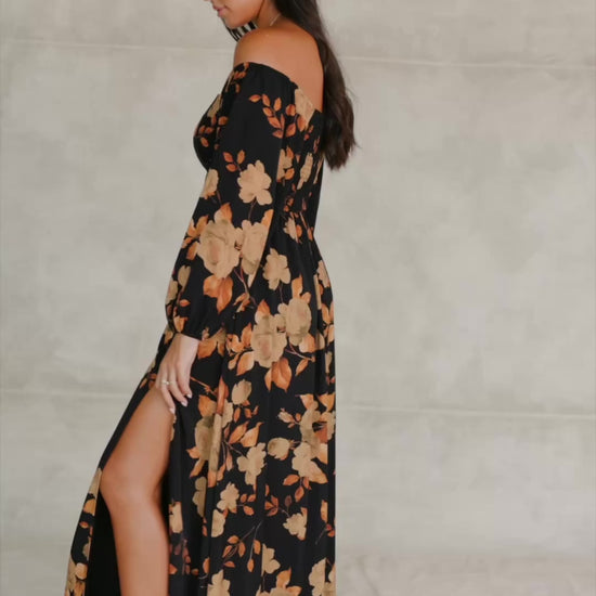 Cordelia Off Shoulder Maxi Dress in Black + Gold Floral with an off-shoulder neckline, billowy sleeves, and a leg slit.