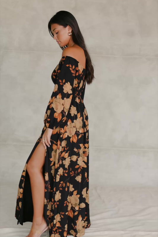 Cordelia Off Shoulder Maxi Dress in Black + Gold Floral with an off-shoulder neckline, billowy sleeves, and a leg slit.