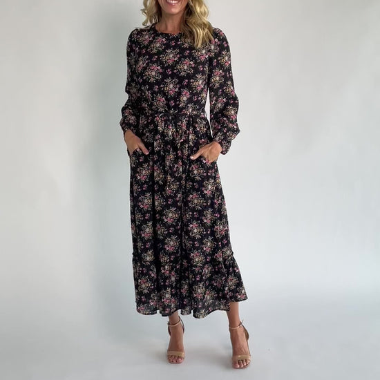 Floral midi dress with a round neckline, long sleeves, smocked back bodice, removable waist tie, tiered skirt, and back keyhole closure.