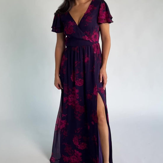 Theodora Maxi Dress in Indigo + Berry with floral print, crossover V-neck, flutter sleeves, elastic waist, and leg slit.