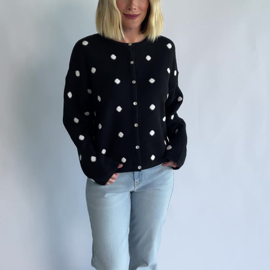 Cinder Cardigan in Black + White Dot with a button-front closure, polka-dot trim, and a relaxed knit silhouette.