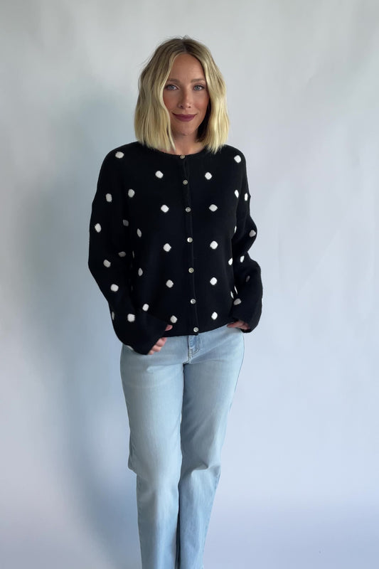 Cinder Cardigan in Black + White Dot with a button-front closure, polka-dot trim, and a relaxed knit silhouette.