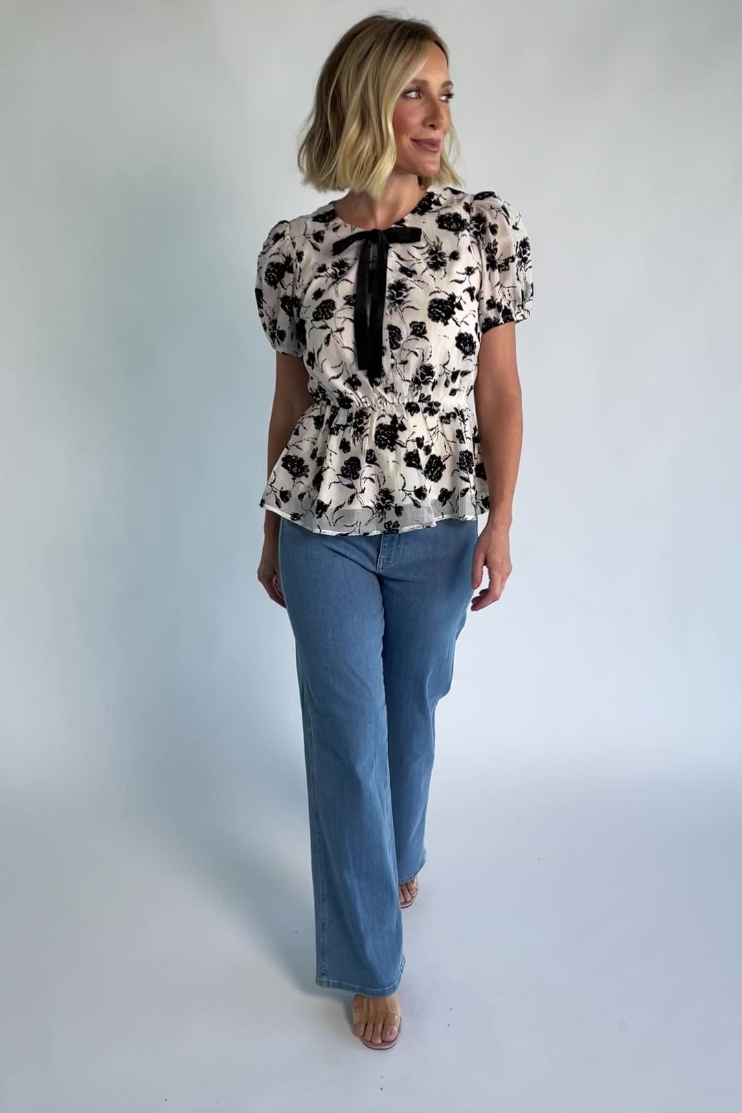 Gwenyth Peplum Blouse in Ivory + Black with velvet florals, front bow, puff sleeves, and elastic peplum waist.