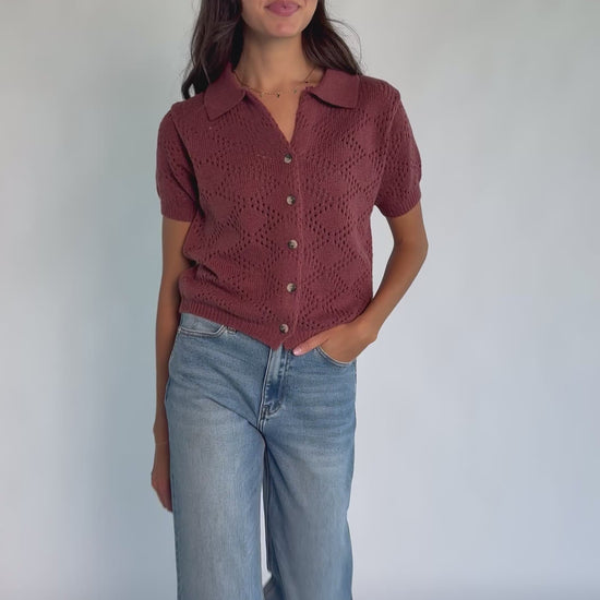 Model wearing a dark clay openwork knit cardigan with a V-neckline, short sleeves, five-button front closure, and a relaxed silhouette.