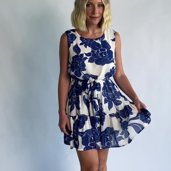 Alanya Short Dress in Off White + Blue Floral with round neckline, tank-style sleeves, and tiered skirt.