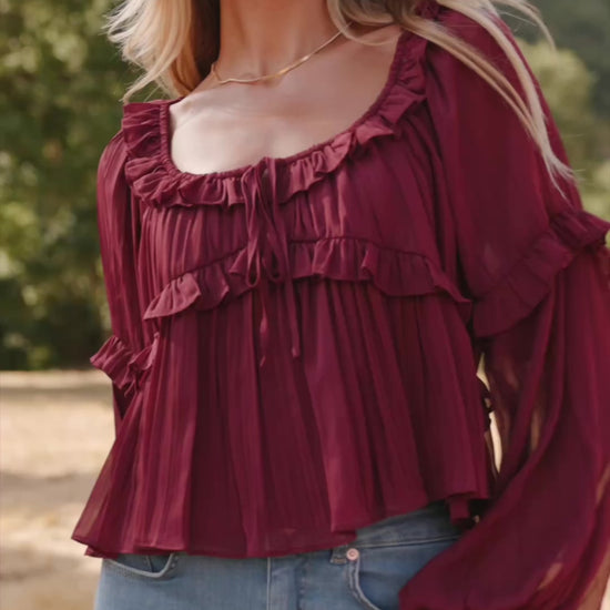 Bellerose Ruffle Top in Burgundy with pleated chiffon, ruffle-trimmed neckline, front tie, and billowy long sleeves.