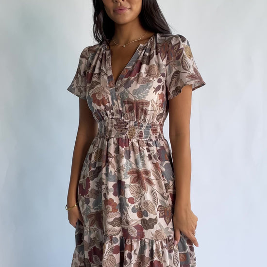 Holland Dress in Taupe Multi with a smocked waist, V-neckline, flutter sleeves, and a floral print.