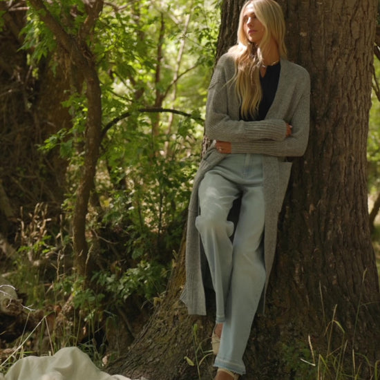 Bria High Rise Wide Leg Jeans in Light Wash with relaxed wide legs, front and back pockets, button closure, and raw hem.